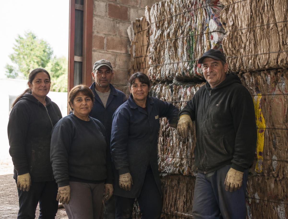 Trabajadores de una cooperativa clasificando materiales sobre una cinta transportadora